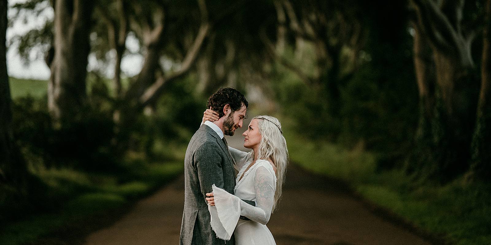 A bride who looks like Daenerys Targaryen - Khaleesi and her groom gaze at each other on the Kings Road from Game of Throne which is know as the Dark Hedges in Co Antrim, Northern Ireland