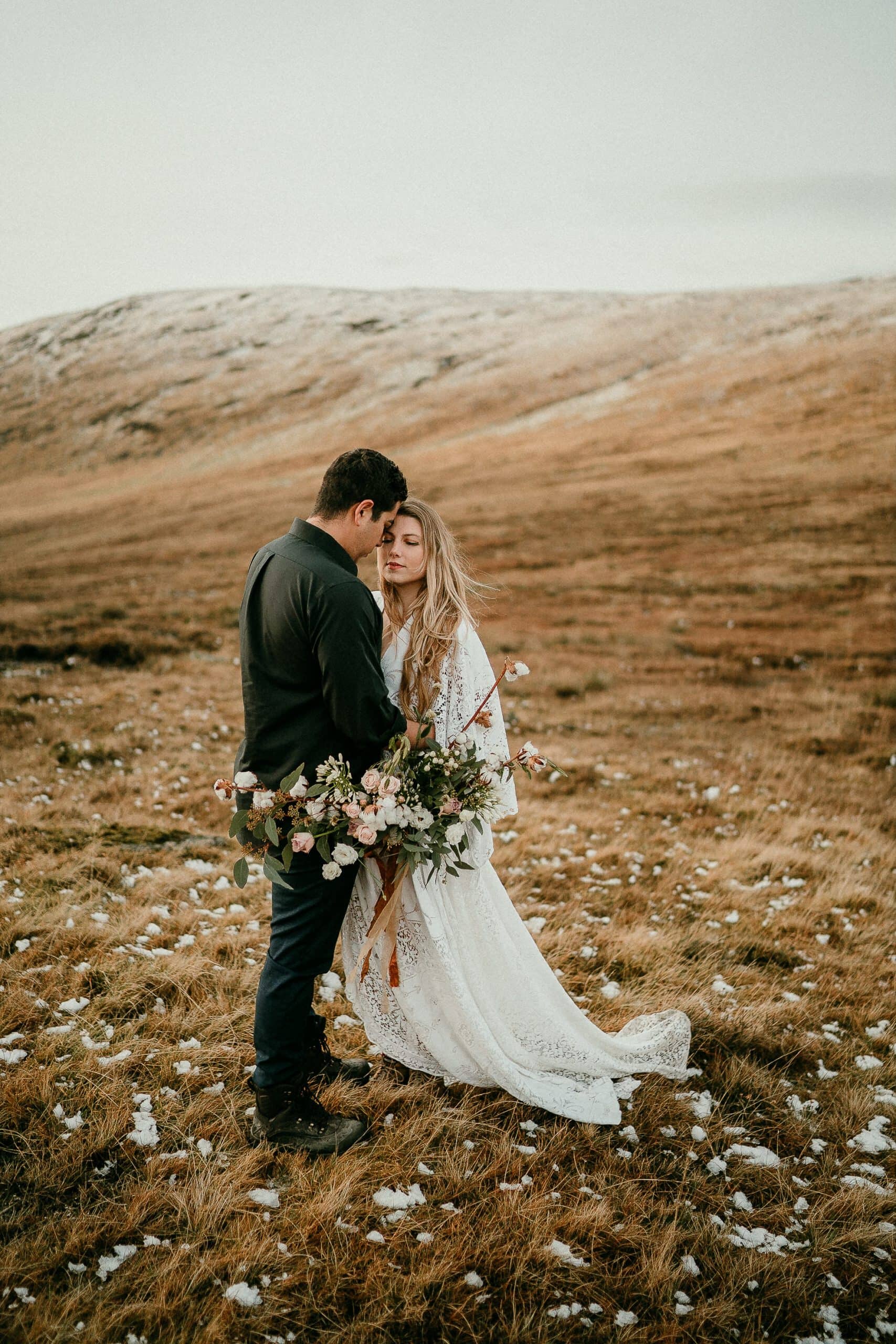 Elopement on snow capped mountains in Ireland. Northern Ireland elopement inspiration on the Mourne Mountains. Boho dress, huge bouquet. 