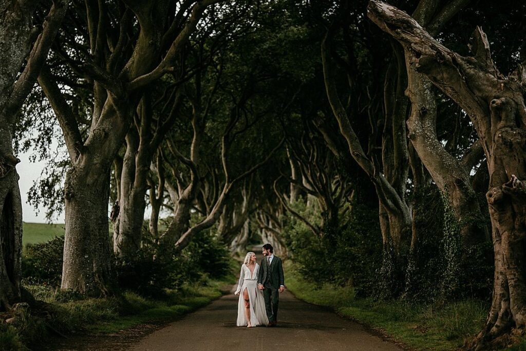 A bride and groom walking in the Dark Hedges aka Kings Road from Game of Thrones. The bride is styled as Khaleesi.