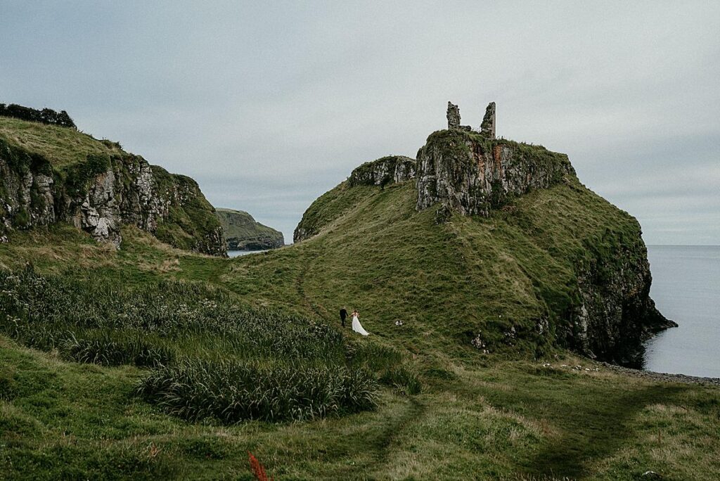 Bride and groom walking in the valley at Dunseverick Castle on their elopement wedding day.