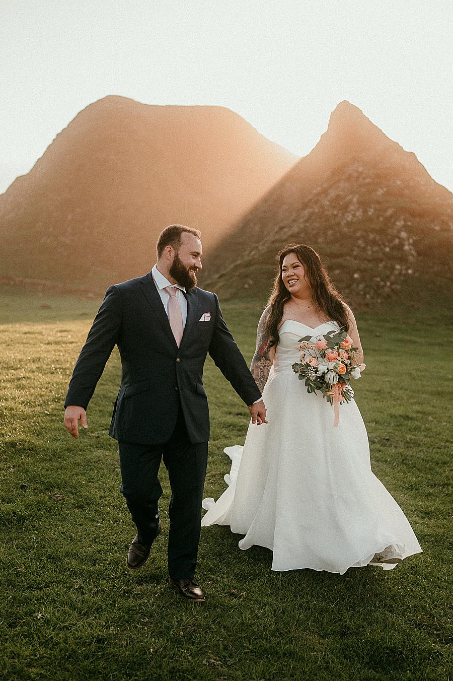 A happy couple on their Ireland Elopement day walking in the rocks at Ballintoy harbour
